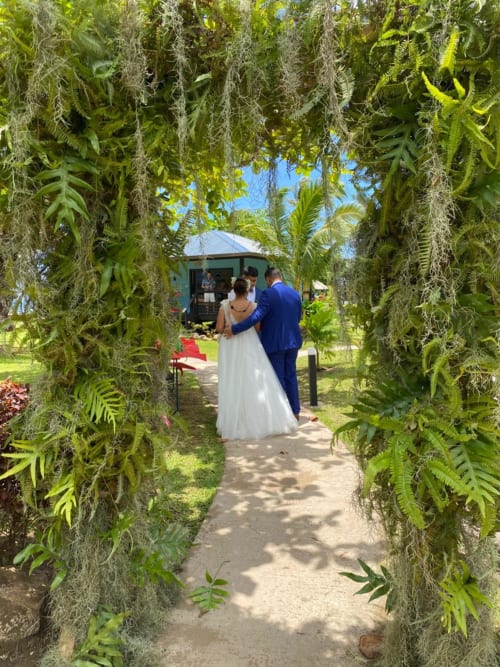 Couple walking through lush tropical garden archway at Sublime Tahiti Beach Retreat, Tahiti