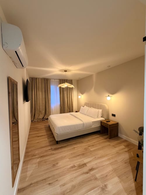 Elegante habitación doble superior en Tinto Dreams Hostel de Haro con cama queen, iluminación colgante y suelo de madera
