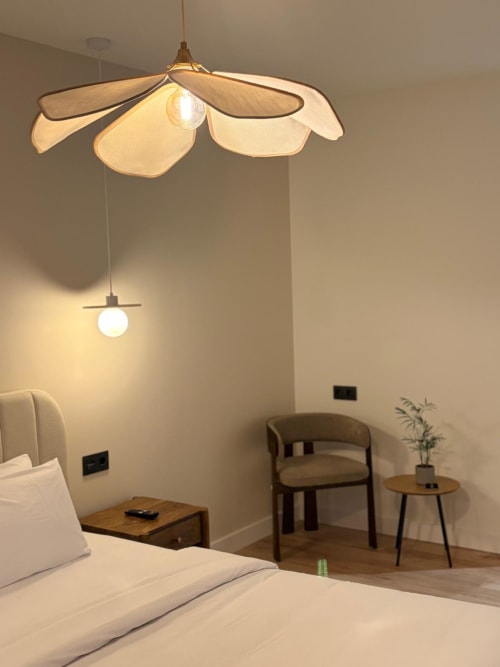 Habitación moderna en Tinto Dreams Hostel de Haro con lámpara colgante de diseño, cama, silla de madera y decoración minimalista