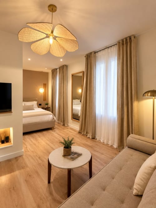 Suite de lujo en Tinto Dreams Hostel en Haro con araña moderna, decoración beige, dormitorio, sala de estar y vista a la ciudad
