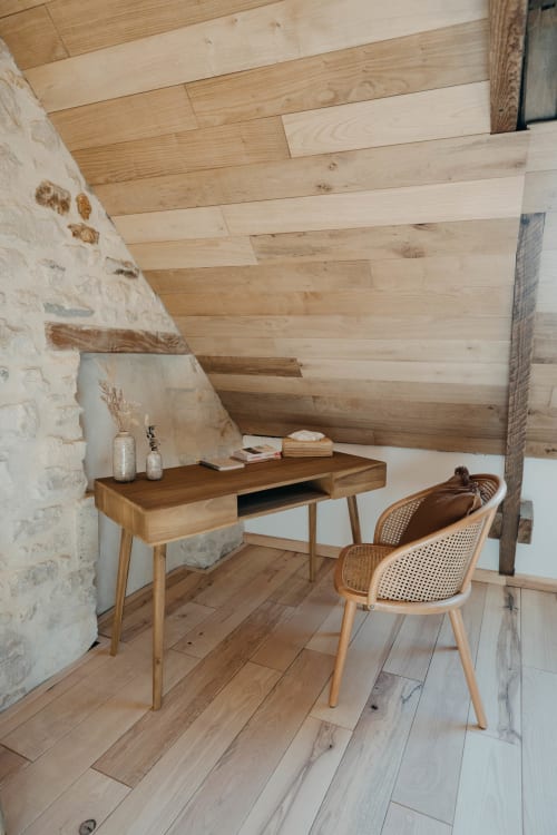 Attic workspace in Suite Lushoto at Le Clos d'Omaha with wooden desk, rattan chair, and exposed beams