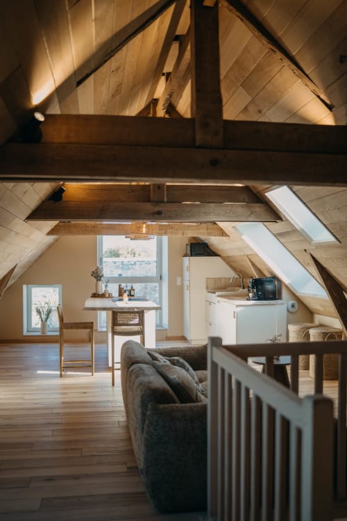 Suite Lushoto loft apartment at Le Clos d'Omaha with exposed beams, living area, kitchenette, and garden views