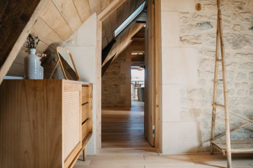 Suite Lushoto hallway at Le Clos d'Omaha with wooden floors, stone walls, and modern furnishings