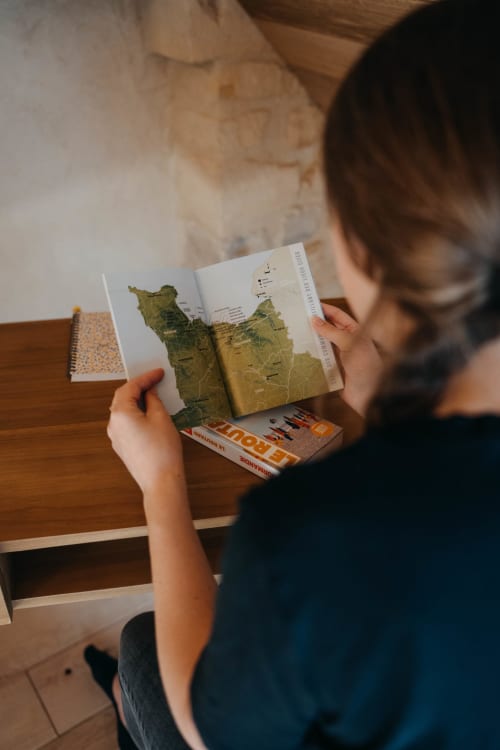 Guest studying a map of Normandy at Le Clos d'Omaha hotel in Englesqueville la Percée