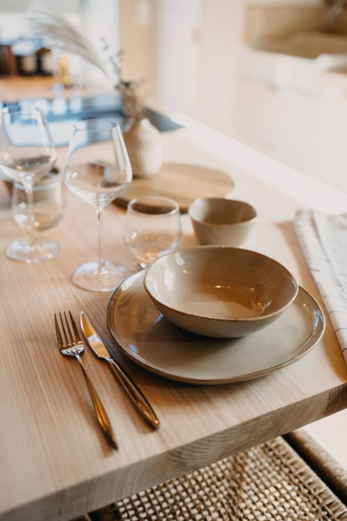 Elegant table setting at Le Clos d'Omaha with plated dishes, wine glasses, and place settings in Suite Lushoto