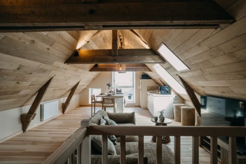 Bright attic suite at Le Clos d'Omaha with exposed wooden beams, skylights, living area, kitchenette, and garden views