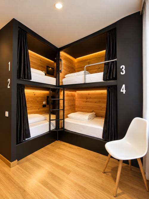 Moderna habitación cuádruple con cuatro literas tras cristal en el Tinto Dreams Hostel de Haro, España