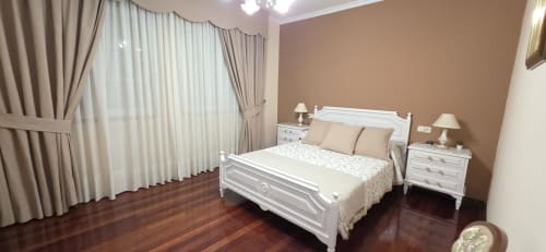 Elegante dormitorio en el apartamento Casa Amma de Bikarte Alojamientos, Monforte de Lemos, con cama blanca, paredes cálidas y