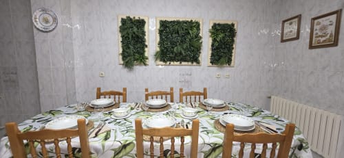 Comedor de Casa Amma con mesa puesta, sillas de madera, cuadro de plantas y decoración tradicional en Ribeira Sacra