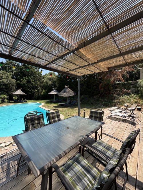Terrasse avec piscine et table de repas sous pergola en bois à Mas Provençal, Bollène