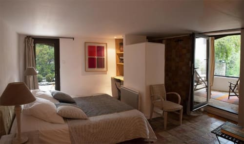 Chambre spacieuse au Clos des Amandiers B&B à Simiane-la-Rotonde avec lit, accès à la terrasse et éclairage chaleureux