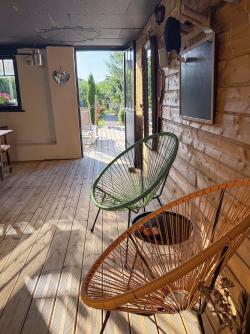 Chaises tressées vert et orange sur terrasse en bois du gîte l'Atelier des Dépendances, Lipsheim