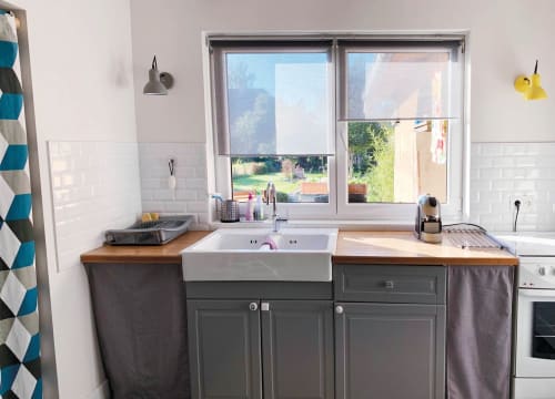 Cuisine moderne aux carreaux métro blancs, meubles gris et vue sur le jardin du gîte l'Atelier des Dépendances à Lipsheim