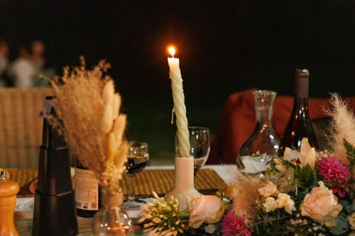 Élégante table de dîner aux chandelles à La Petite Plaine B&B à Clansayes, agrémentée de vin et d'arrangements floraux