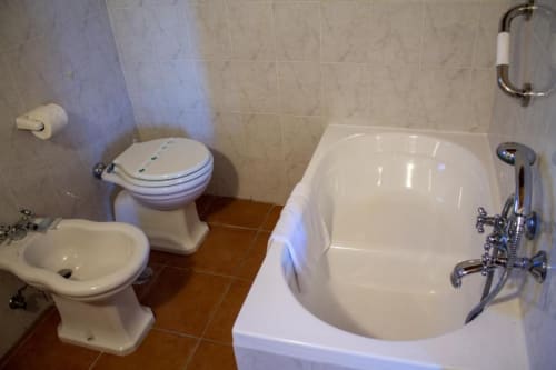 Bagno della camera Belvedere Sopra dell'Antico Belvedere B&B con toilette, lavandino, vasca bianca e doccia