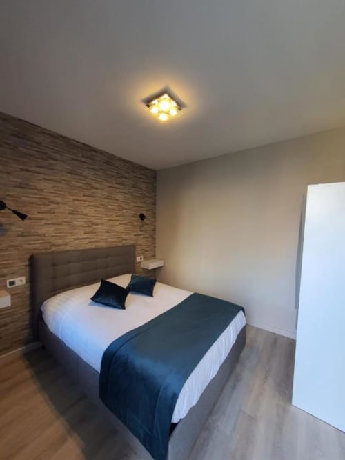 Chambre double contemporaine au New Windsor Hotel ETRETAT avec mur en bois, literie blanche et luminaire au plafond
