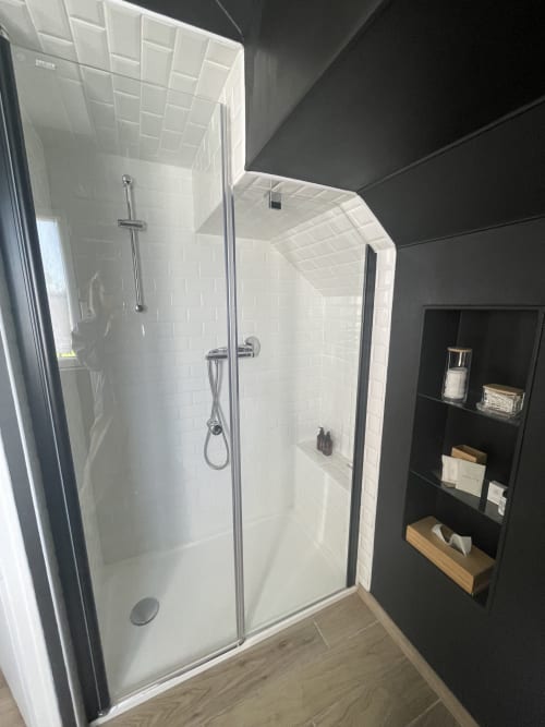 Salle de bains moderne avec carrelage blanc et pommeau de douche cascade au gîte Le Clos d'Émilie, Saint-Marcel