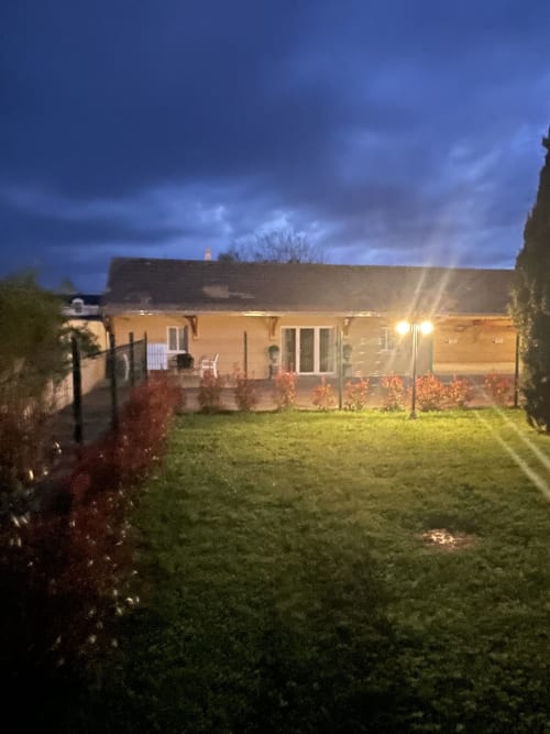 Le Clos d'Émilie au crépuscule, façade illuminée, pelouse soignée et jardin à Saint-Marcel