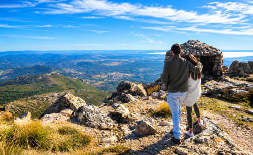 Pareja disfrutando de vistas panorámicas desde la cima de la montaña cerca de El descanso del peregrino en Guadalupe, Cáceres