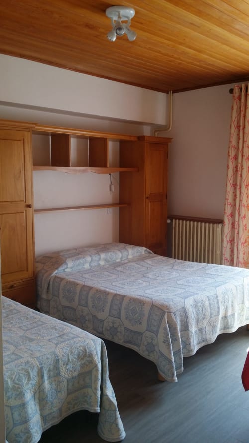 Chambre twin à l'Hôtel Les Fleurs à Morzine avec mobilier en bois, deux lits et décoration alpine