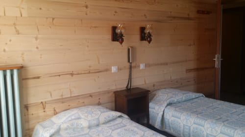 Chambre familiale douillette à l'Hôtel Les Fleurs à Morzine avec deux lits et murs en pin rustique