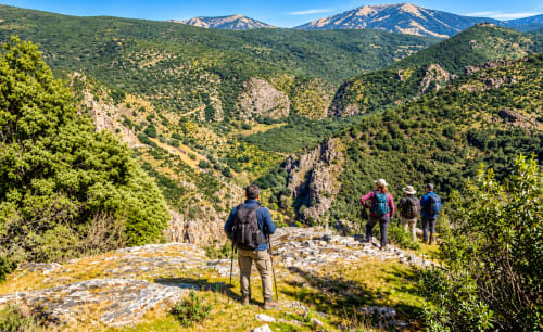 Excursionistas disfrutan de vistas del valle montañoso en Guadalupe, Cáceres - El descanso del peregrino
