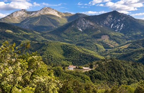 Vista aérea de El descanso del peregrino en los valles boscosos cerca de Guadalupe, Cáceres, España, rodeado de montañas.
