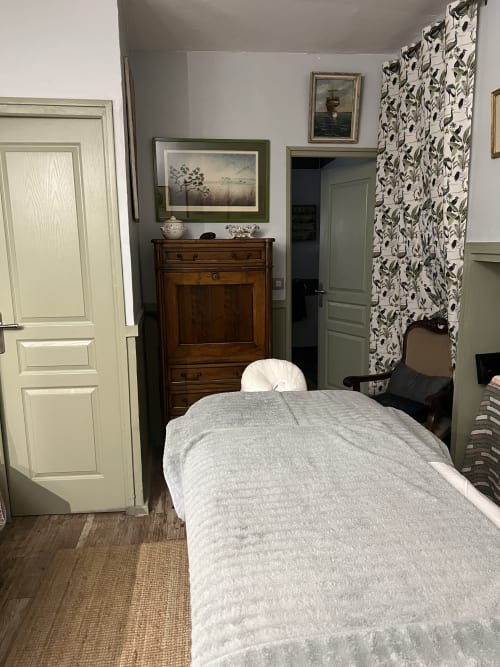 Cozy bedroom at Domaine Du Commandeur B&B in Mondragon, France, with cream doors and floral curtains