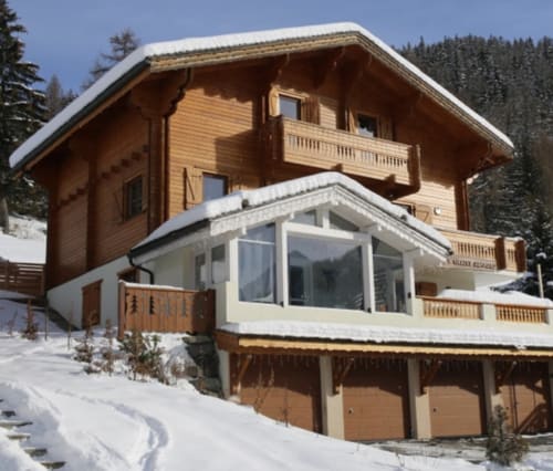 Villa Le Chalet Savoyard à La Plagne Tarentaise, architecture bois et extension vitrée moderne face aux sommets enneigés