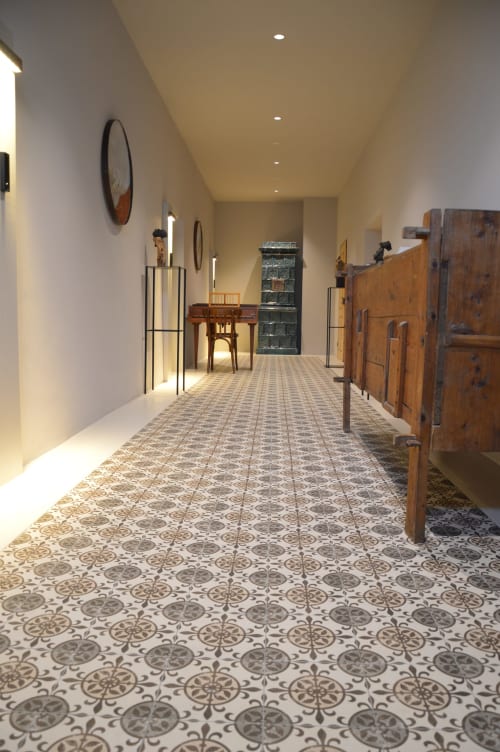 Elegante corridoio di Villa Rosati con piastrelle decorate, mobili in legno e illuminazione ambientale a Sanzeno