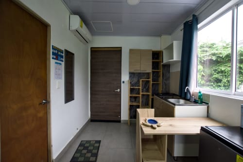 Moderna cocina y comedor en apartamento Calamares de Vamos pa San Andrés Isla con mesa de madera, fregadero y estantes de almacenamiento