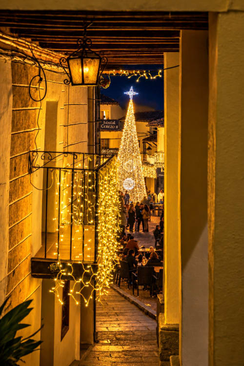 Decoración navideña festiva en El descanso del peregrino de Guadalupe, Cáceres, con árbol iluminado y luces ornamentales