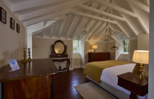 Quarto espaçoso na Casa da Lagoa em Furnas com teto abobadado, cama de madeira, escrivaninha e móveis clássicos