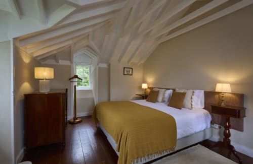 Quarto luminoso na pousada Casa da Lagoa em Furnas com vigas à vista, cama de casal, móveis de madeira e vista para o lago