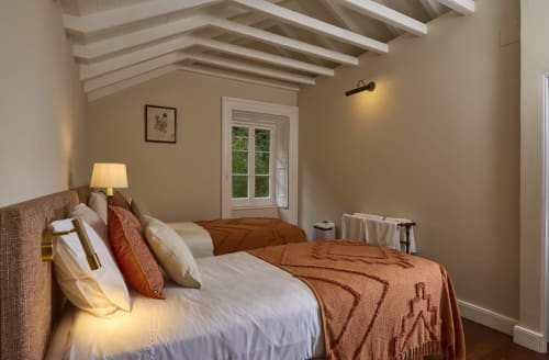Quarto aconchegante da Casa da Lagoa em Furnas com vista para o lago, teto com vigas aparentes e tons naturais