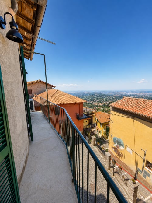 Terrazza balconata dell'hotel Habemus a Rocca di Papa con vista su tetti in terracotta e paesaggio rurale