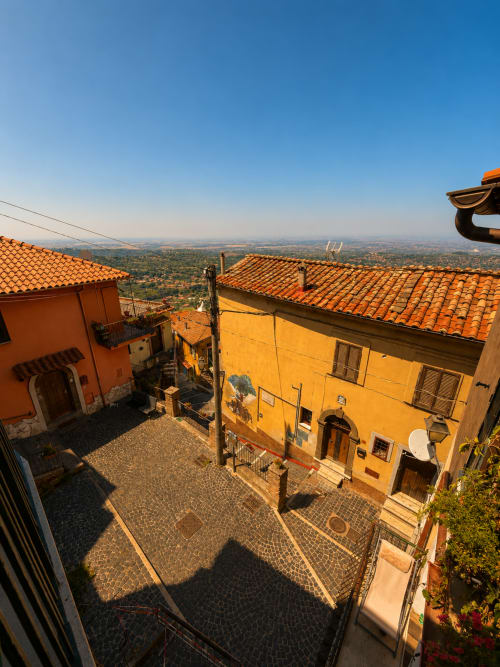 La storica Piazza Vecchia di Rocca di Papa con i suoi tetti in terracotta, edifici gialli e vista sulla campagna dall'hotel Habemus