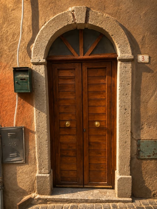 Doppia porta in legno con finestra ad arco all'hotel Habemus di Rocca di Papa, Italia