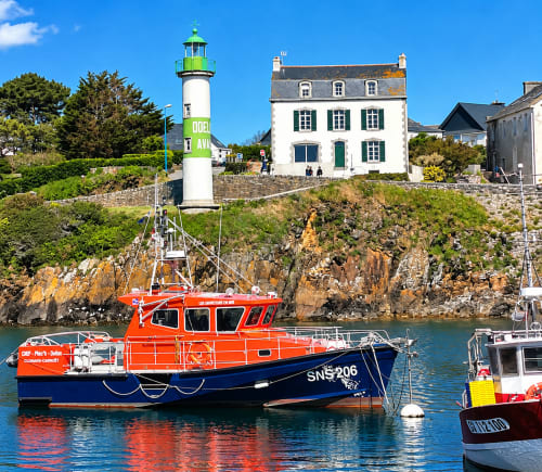 Bateau de sauvetage SNSM dans le port de Doëlan, avec le phare vert et les maisons bretonnes de Clohars-Carnoët, dans le Finistère Sud.