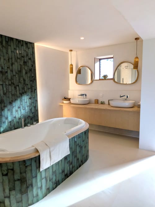 Salle de bain spa moderne au Domaine De La Souche avec baignoire carrelée verte, meuble vasque en bois et miroirs ronds