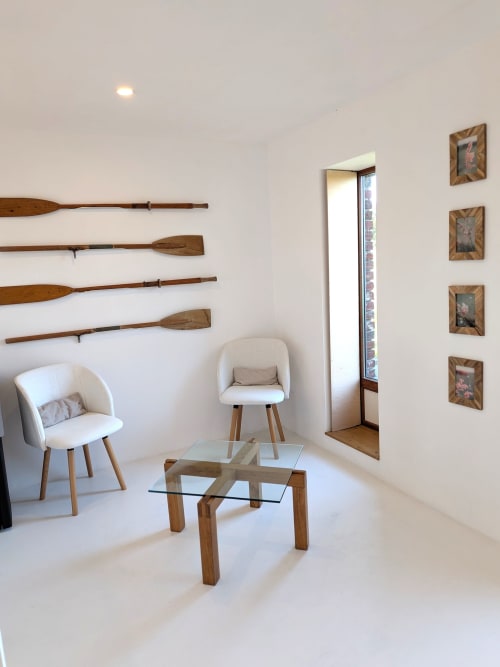 Espace lounge contemporain au Domaine De La Souche avec fauteuils crème, table en verre, avirons et tableaux encadrés