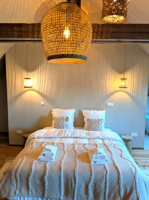 Chambre moderne au Domaine De La Souche avec suspension en tressage, literie patterned et appliques murales