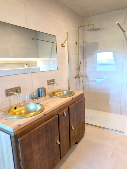 Salle de bain moderne du Domaine De La Souche avec vasques dorées duales, vanité en bois et douche vitrée
