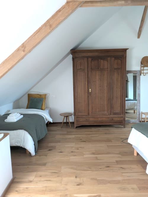 Chambre mansardée à la Domaine De La Souche avec lits jumeaux, armoire en bois et vue sur le jardin à Rexpoëde