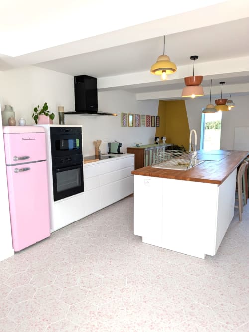 Cuisine moderne au Domaine De La Souche avec réfrigérateur rétro rose, placards blancs, îlot bois et luminaires suspendus