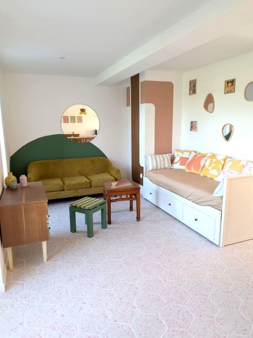 Domaine De La Souche Appartement Sumac : séjour moderne avec canapé olive, lit de jour aux coussins colorés, miroir rond et