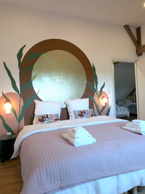 Chambre moderne à la Domaine De La Souche à Rexpoëde avec miroir circulaire en tête de lit, feuillage décoratif et ambiance lumineuse
