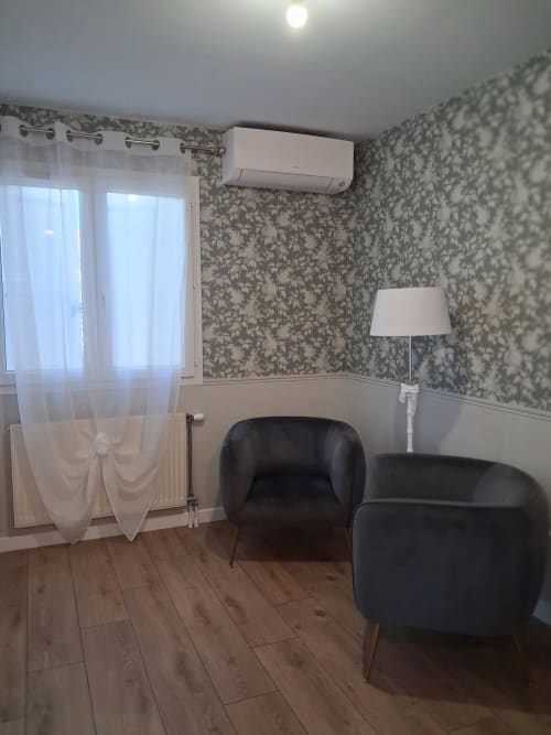 Chambre La Rosée à la Chambres d'hôtes Roséliane à Belleville-en-Beaujolais, avec fauteuils noirs, papier peint à fleurs et climatisation