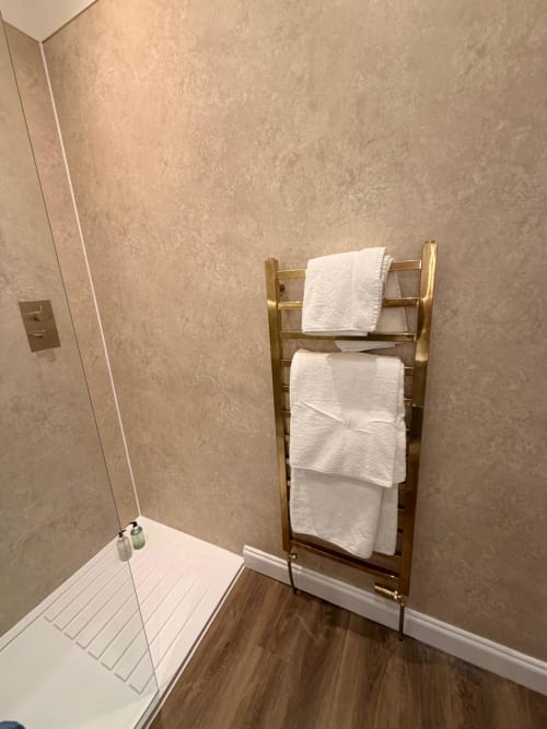 Brass towel rack with white towels in Royal Chambers Glasgow bathroom