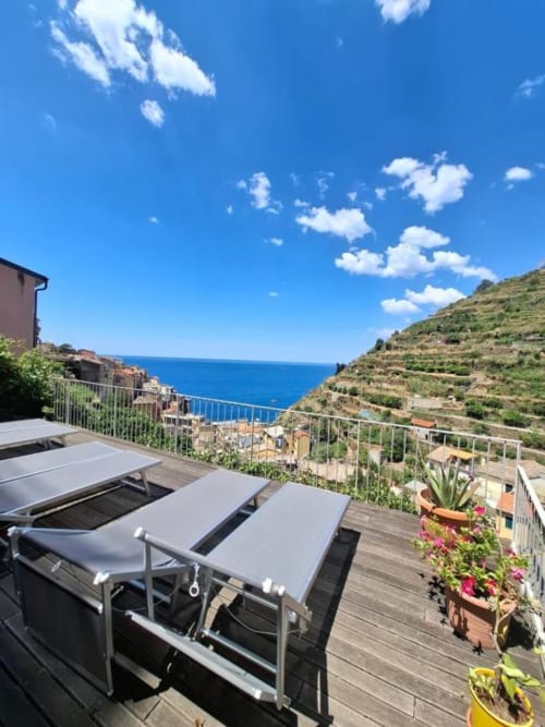 Terrazza dell'Olimpo Affittacamere con lettini prendisole vista sulla costa di Cinque Terre e Mar Mediterraneo, Italia